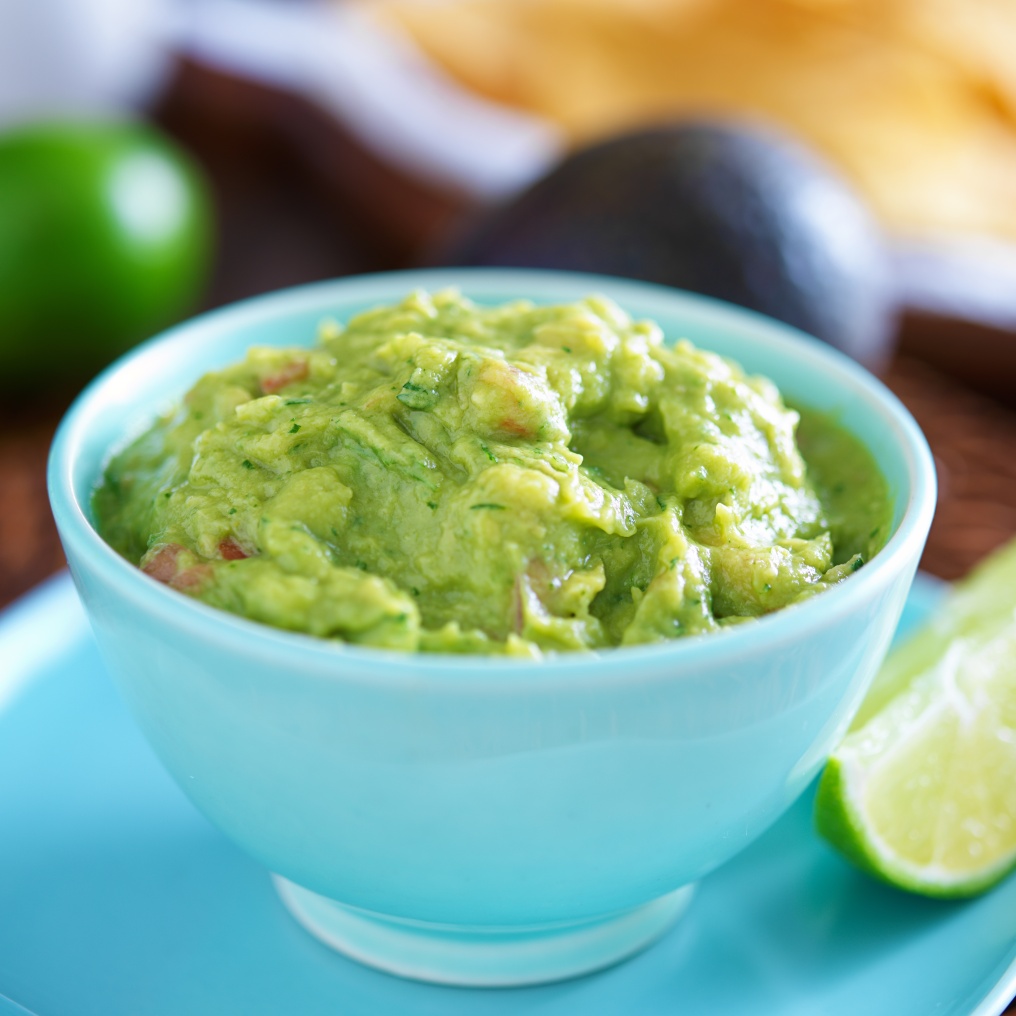 guacamole in colorful blue bowl with tortilla chips