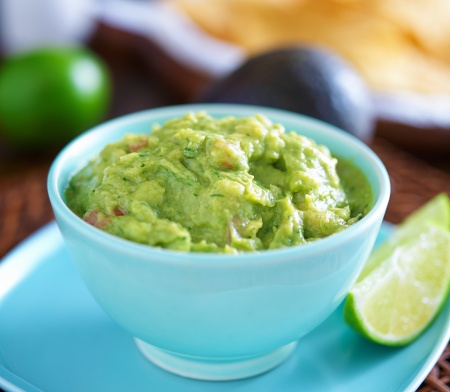 guacamole in colorful blue bowl with tortilla chips
